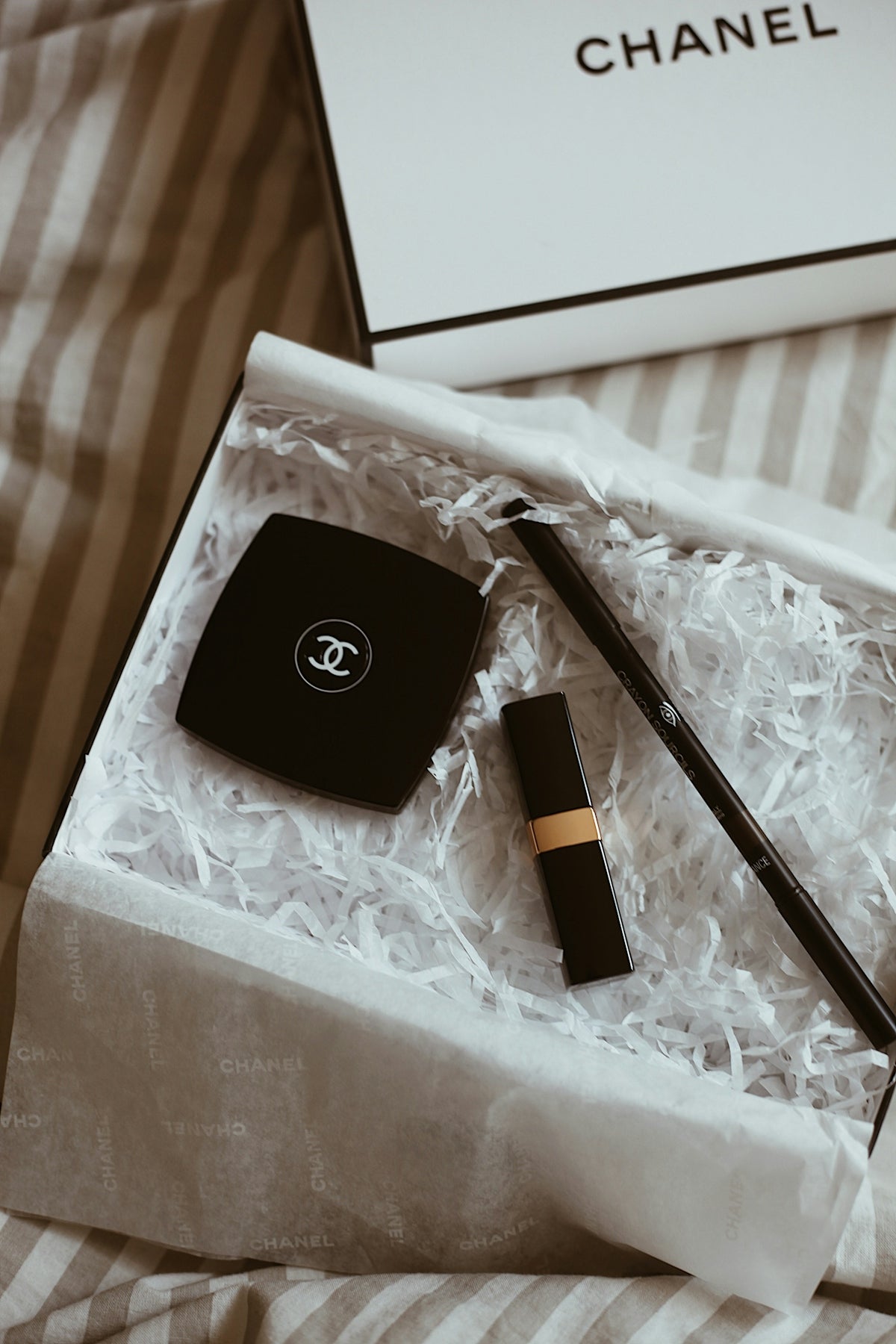 A chanel box with a pen and a watch