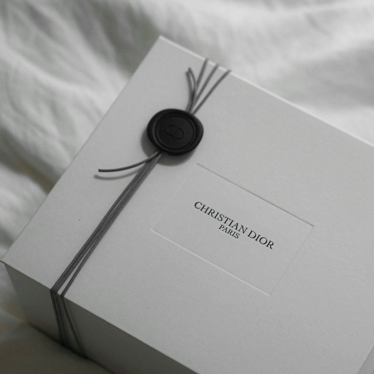 White christian dior gift box with ribbon and wax seal