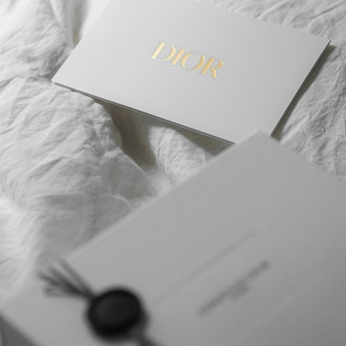 Dior card and gift box on white fabric
