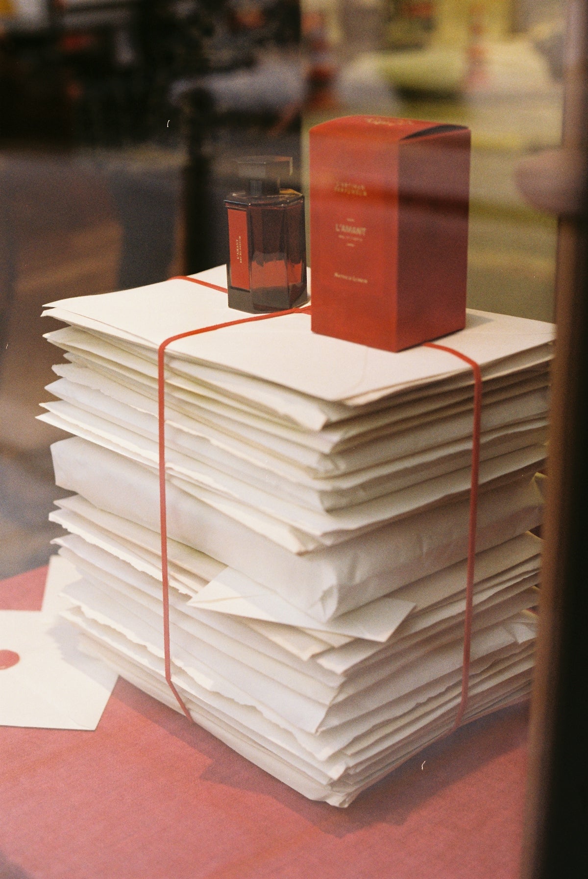 Stack of papers with perfume bottle and box