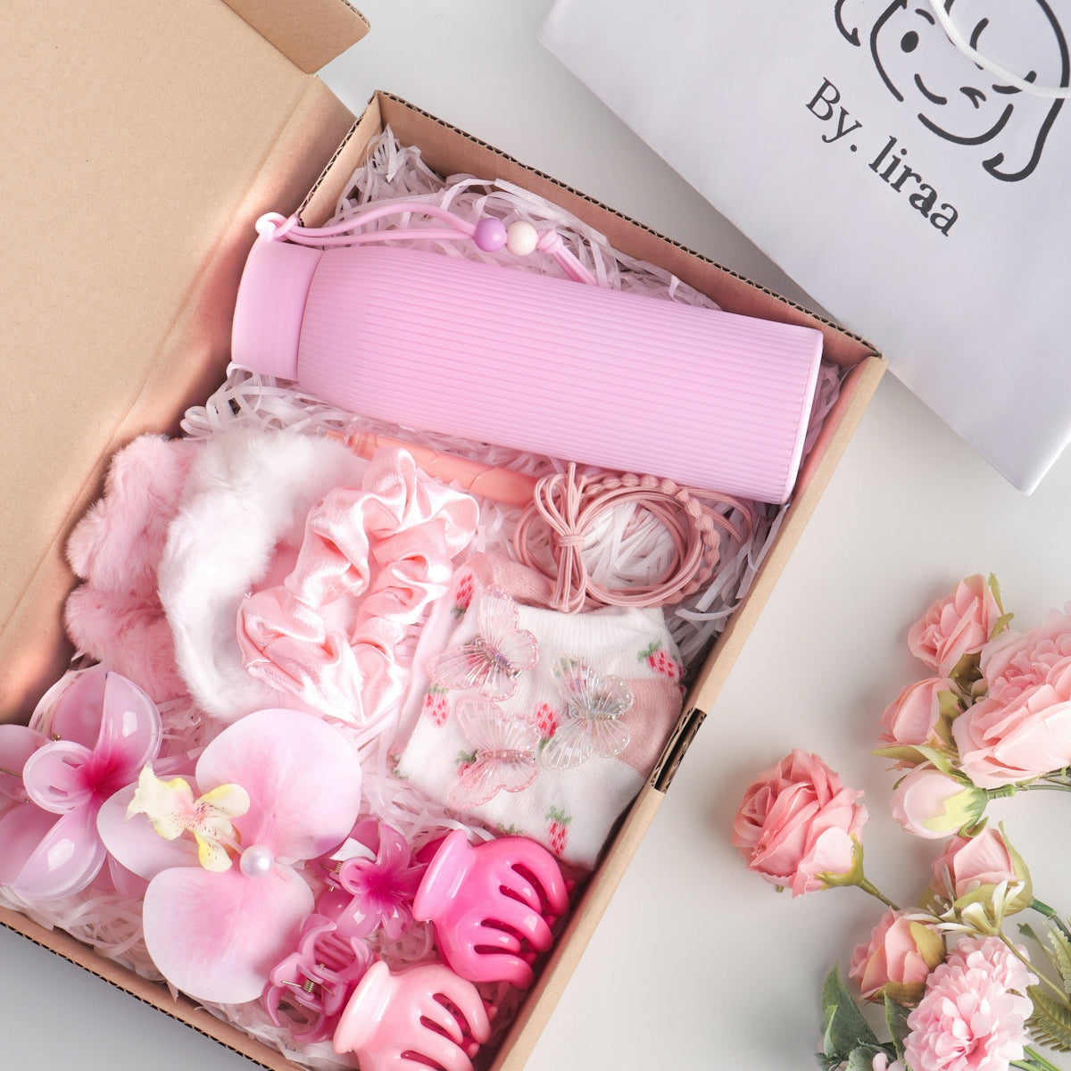 Pink gift box filled with beauty and hair accessories.