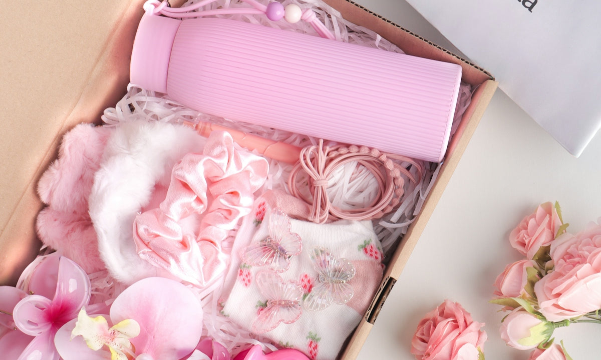 Pink gift box filled with beauty and hair accessories.