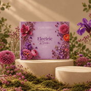 Cohorted The Electric Bloom Edit beauty box displayed on a cream pedestal, surrounded by purple and pink flowers in a botanical setting, beauty boxes, UK, Gift